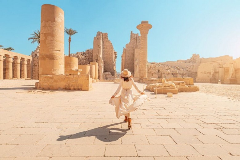  Du khách quàng khăn mỏng che vai khi tham quan đền Karnak